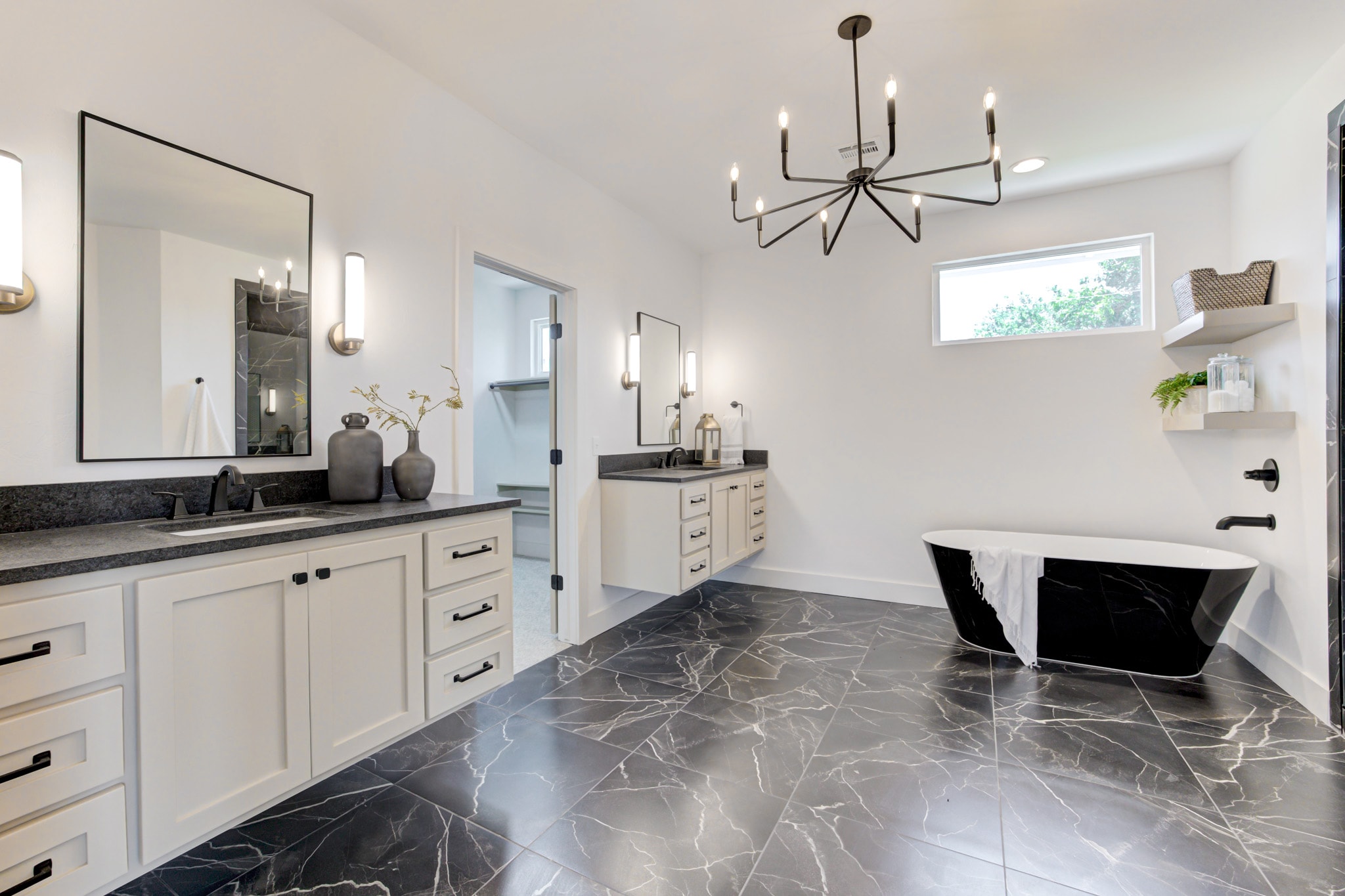 1014 NW 33rd St — primary bath with black freestanding tub and marble tile floor