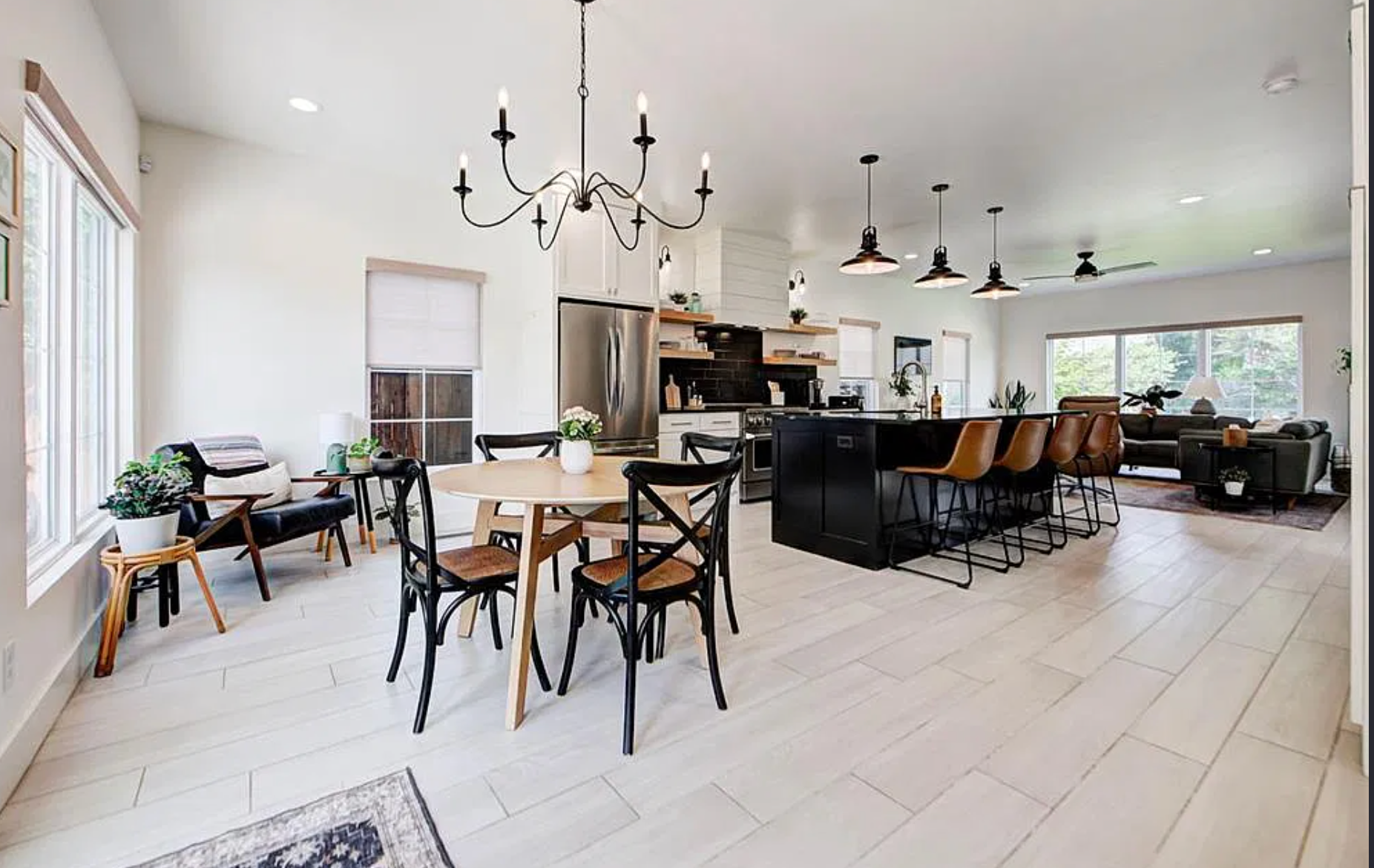 1124 NW 43rd St — kitchen with black island, open shelving and barn pendants
